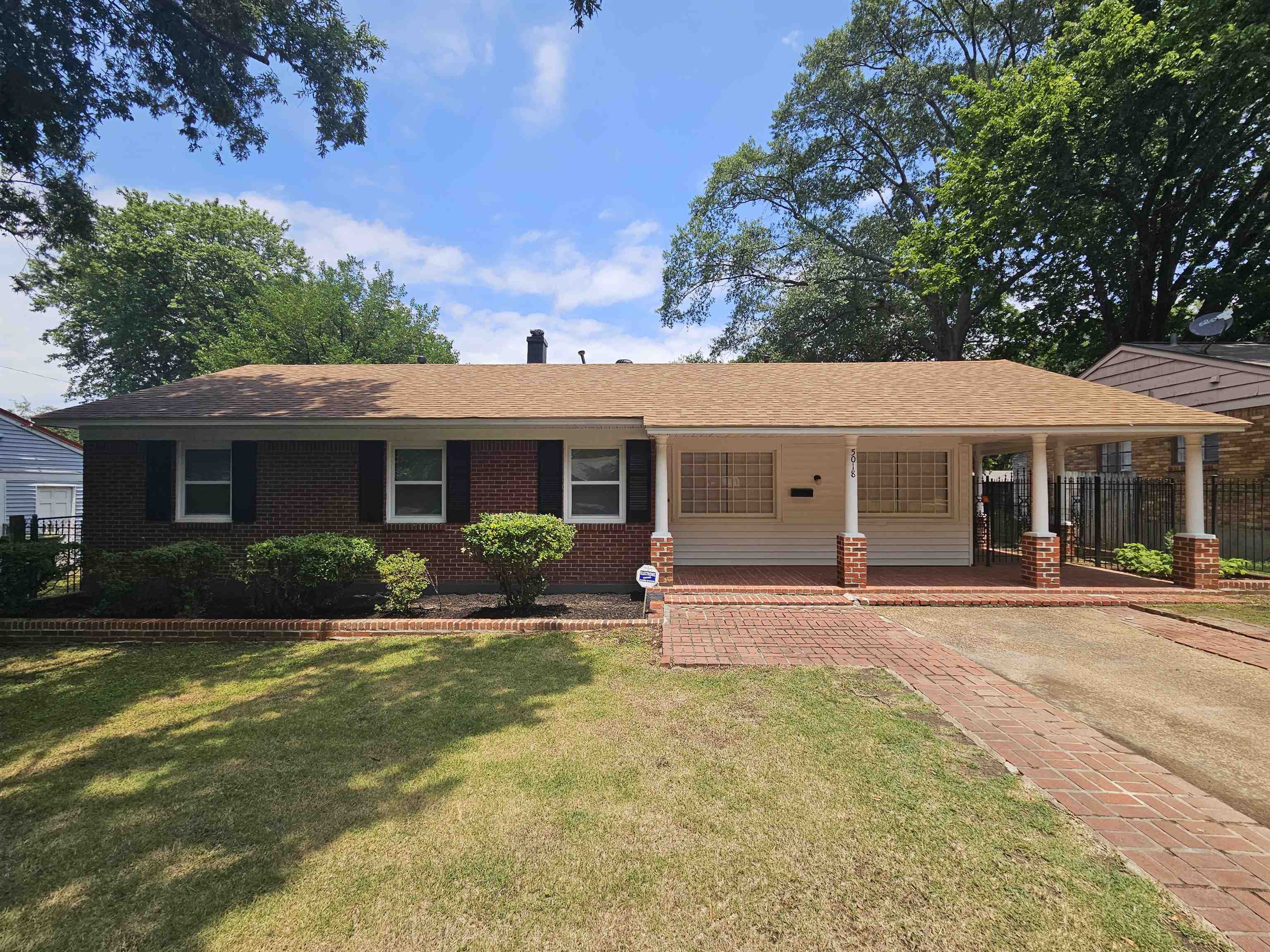 Ranch-style home with a front yard and a porch