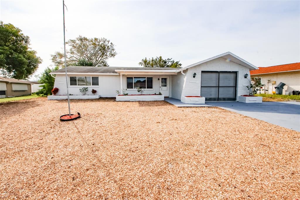 a view of a house with backyard and a tree