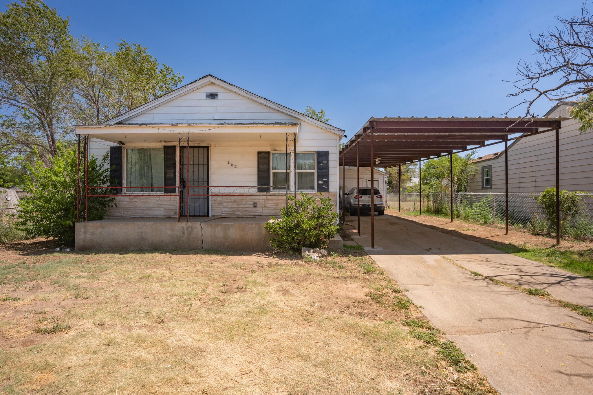 a front view of a house with a yard and potted plants