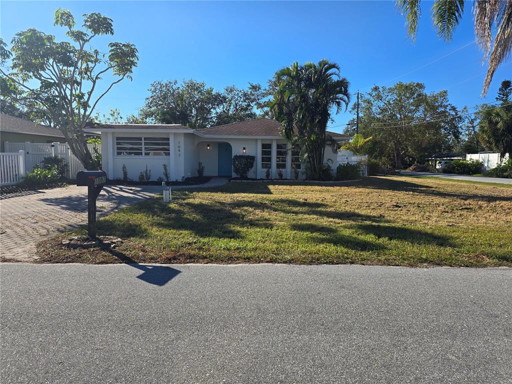 a view of a house with backyard and tree