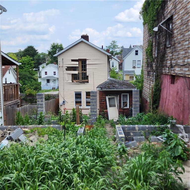 a view of a house with brick walls and a yard with plants