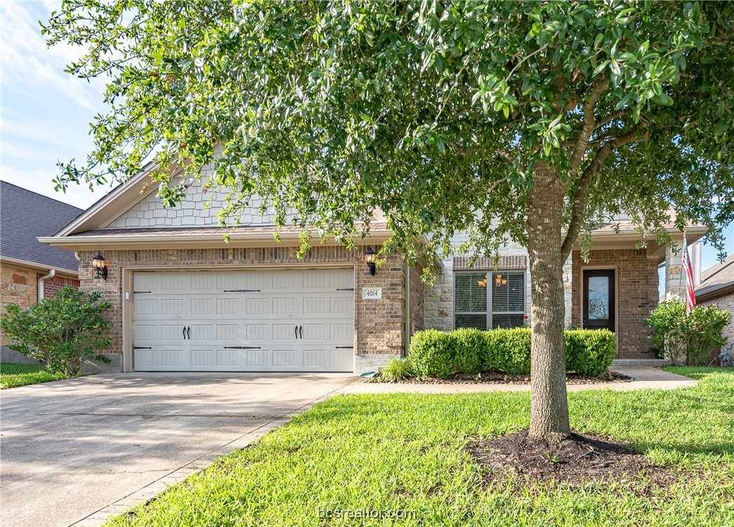 front view of a house with a tree in a yard