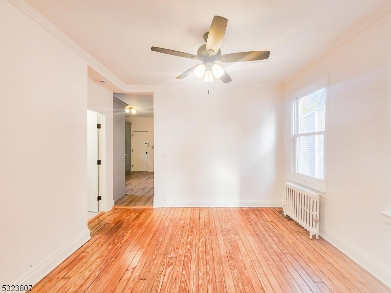 a view of a livingroom with wooden floor and a ceiling fan