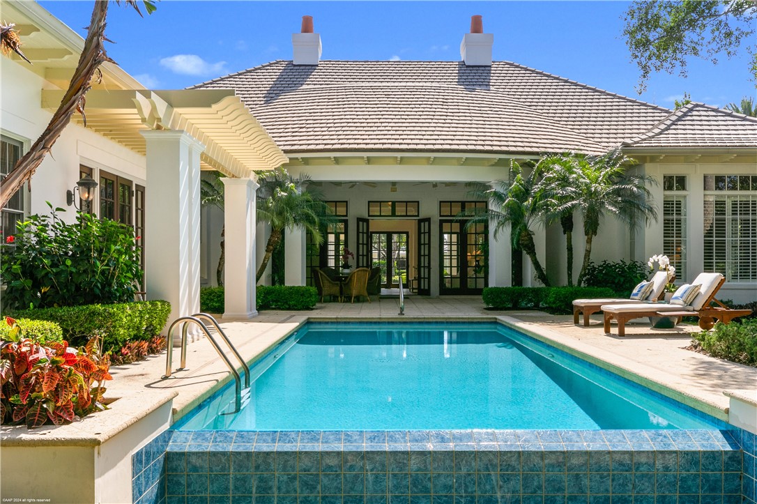 a view of a house with swimming pool and sitting area