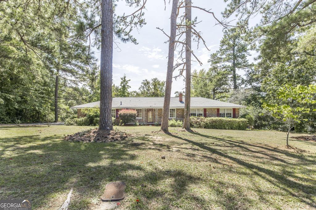 a view of a house with backyard and a tree