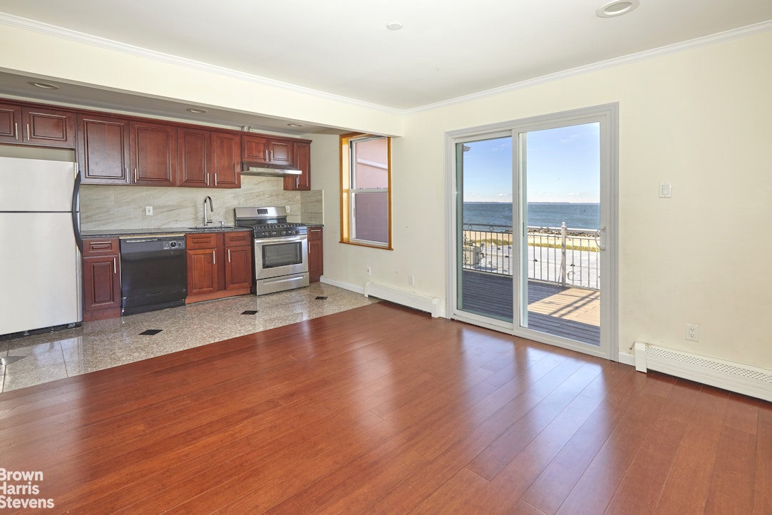 a room with stainless steel appliances wooden floors and wooden cabinets