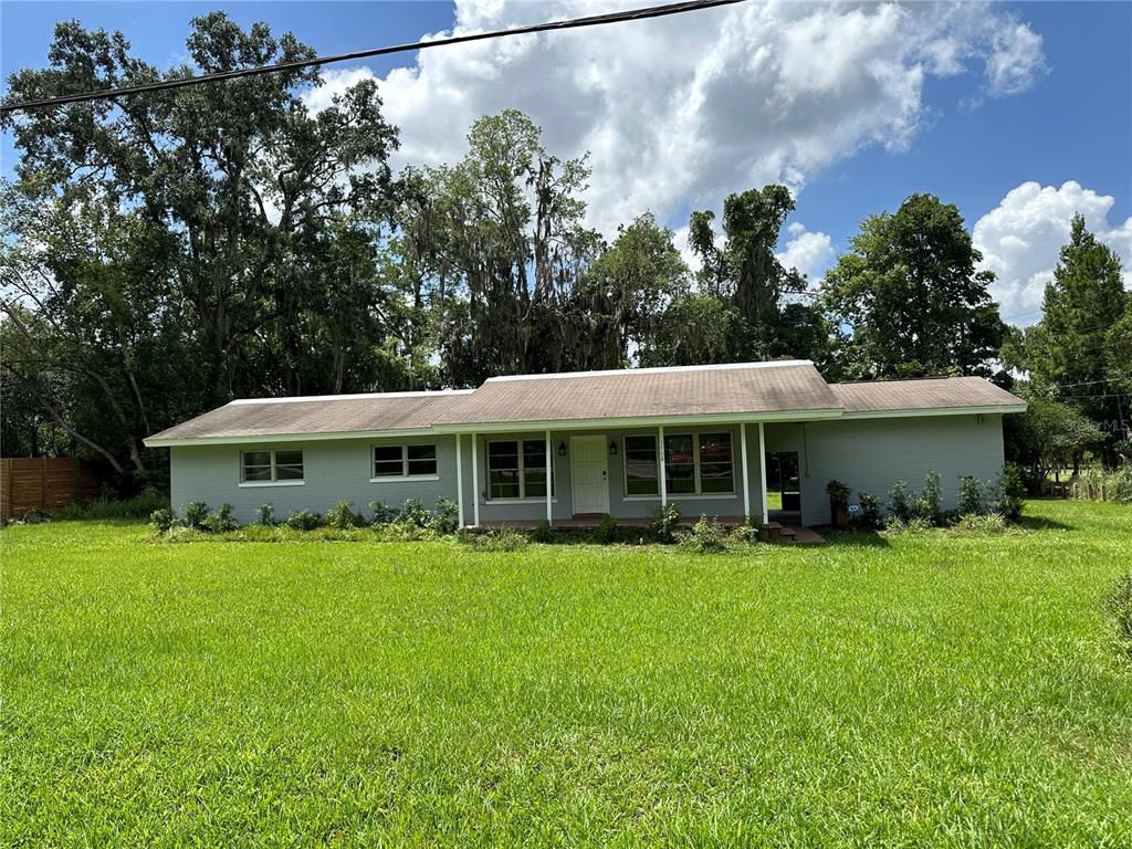 a view of a house with a yard and sitting area