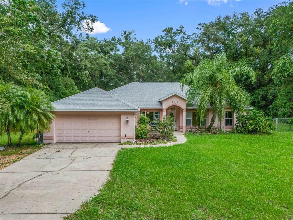 Cozily nestled in about 1.6 acres is this stucco home on Lake Griffin Road - just waiting for your family memories.