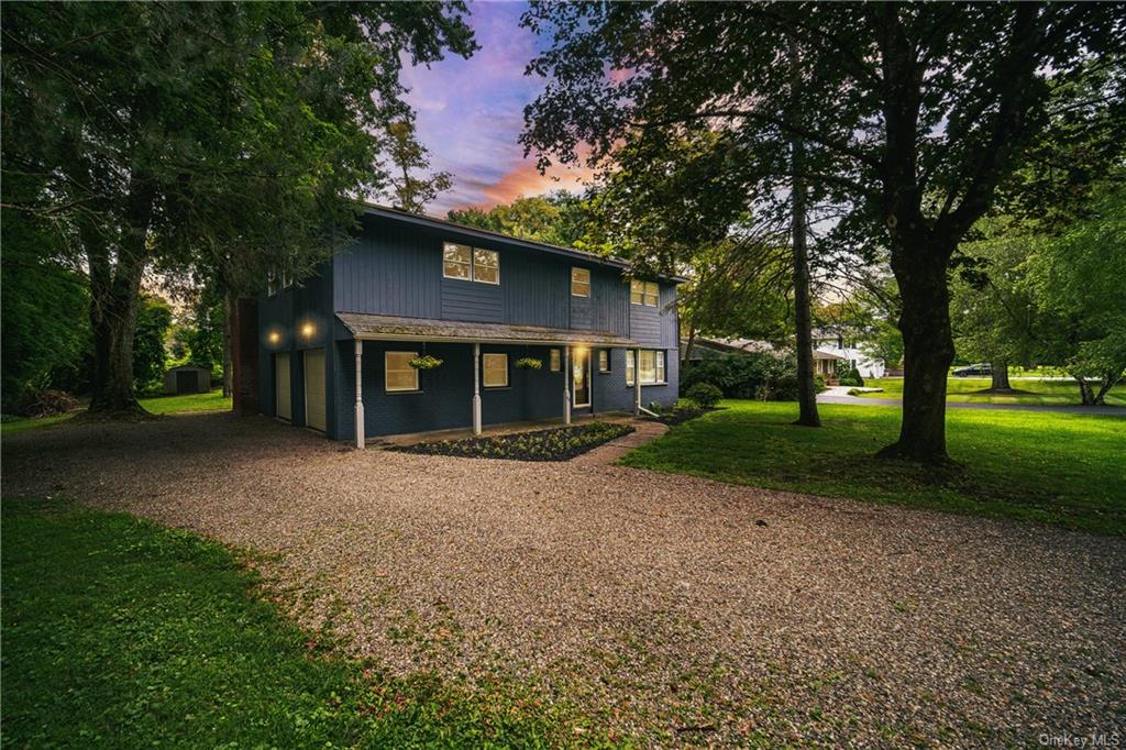 a view of a house with a yard and tree