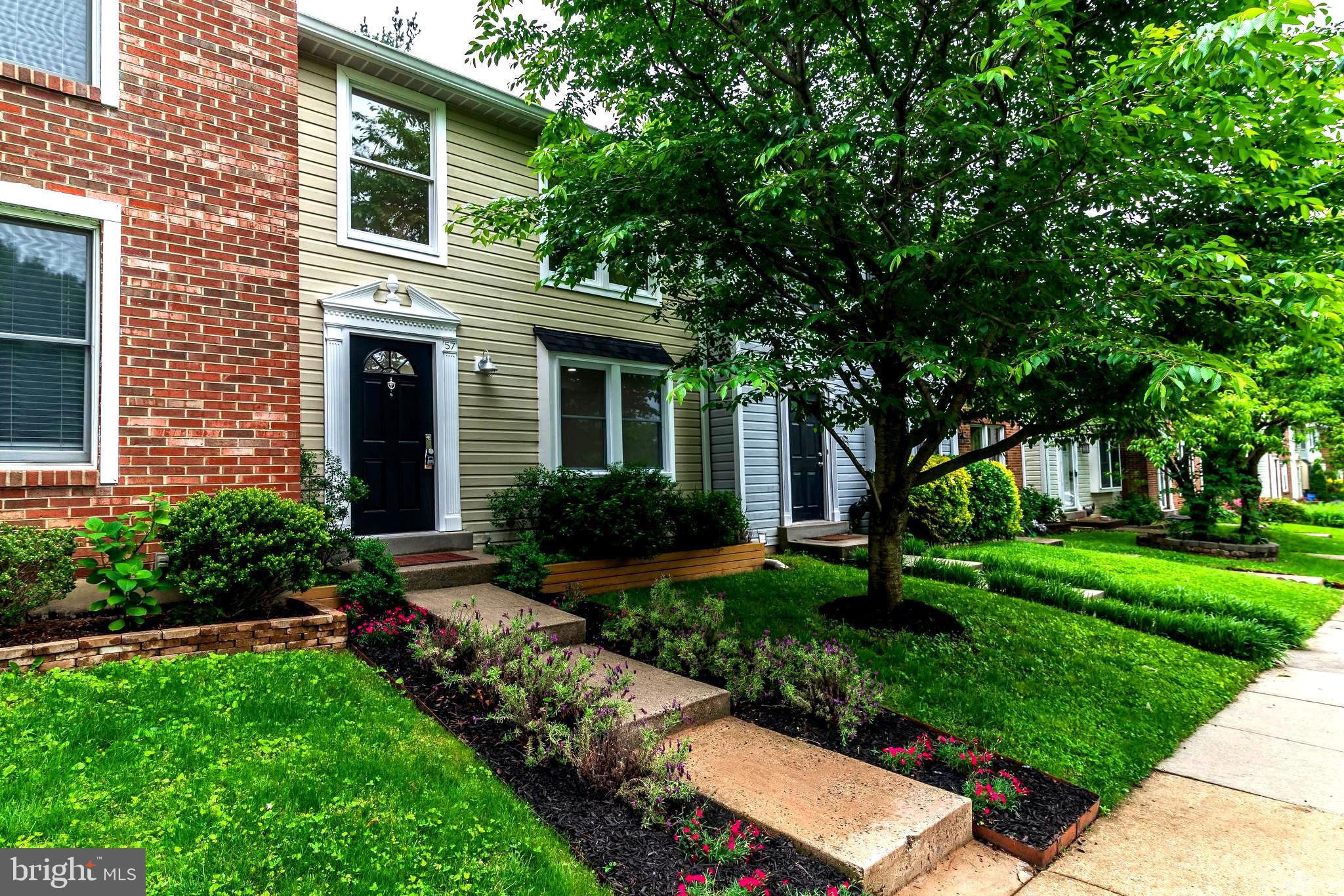 a front view of a house with a yard and potted plants