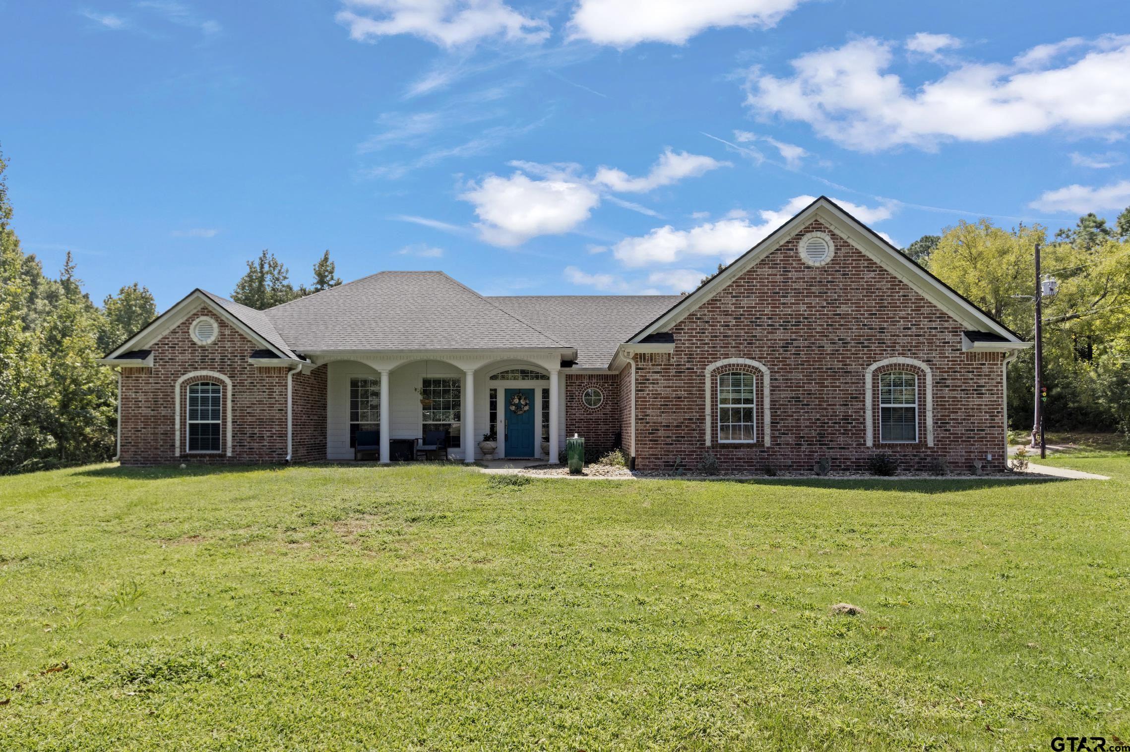 a front view of a house with yard and green space