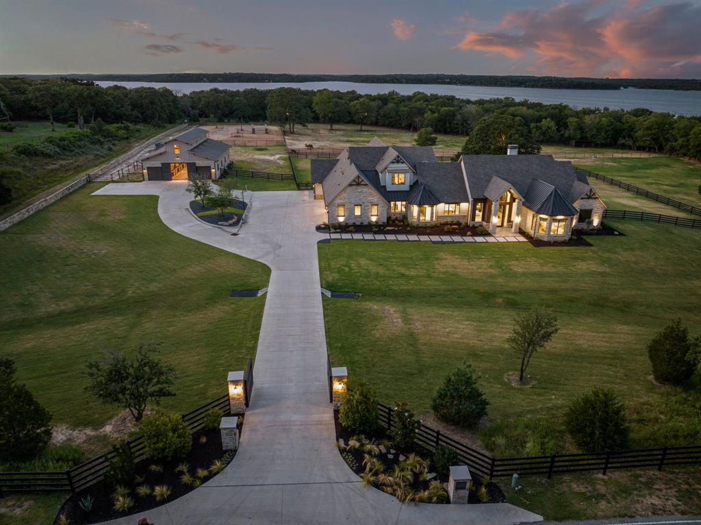 an aerial view of a house with a garden and lake view