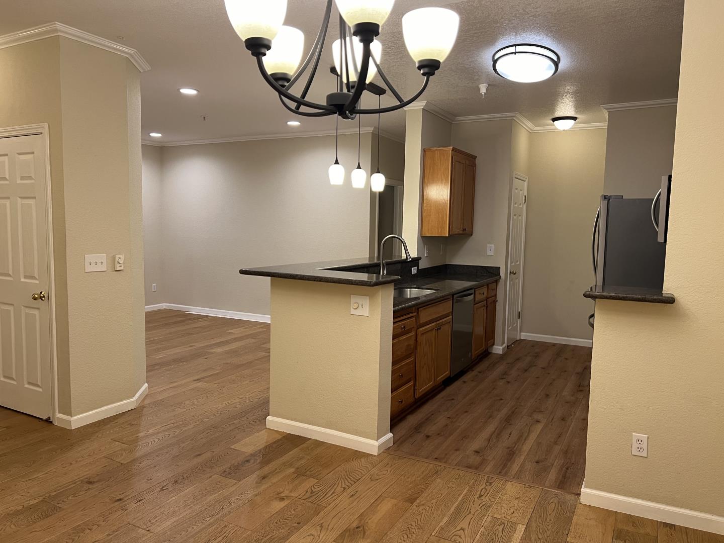 a kitchen with stainless steel appliances granite countertop a stove and a wooden floor