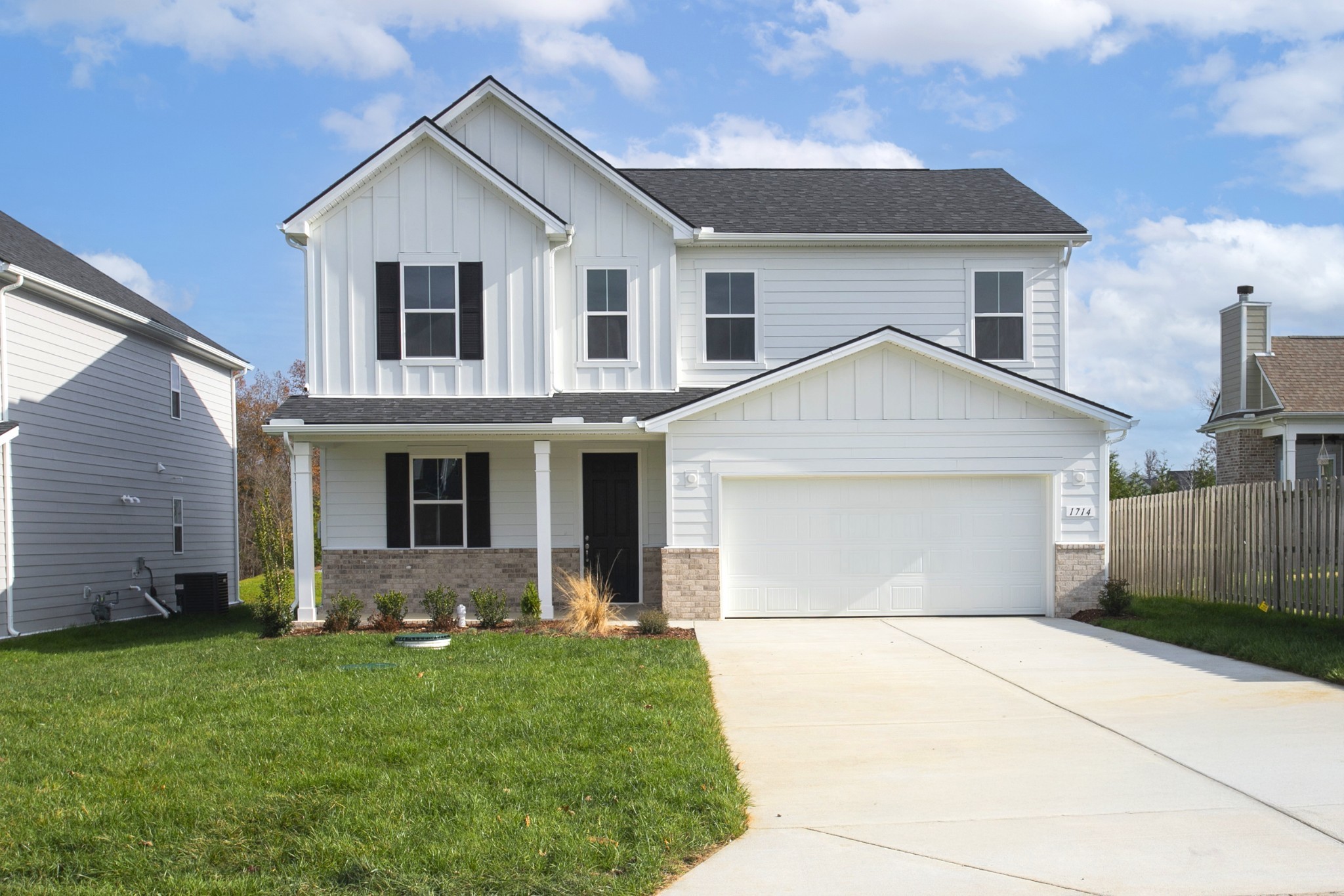 a view of a white house next to a yard and garage