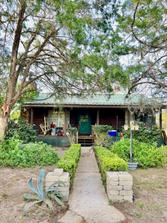 a front view of a house with a garden and plants