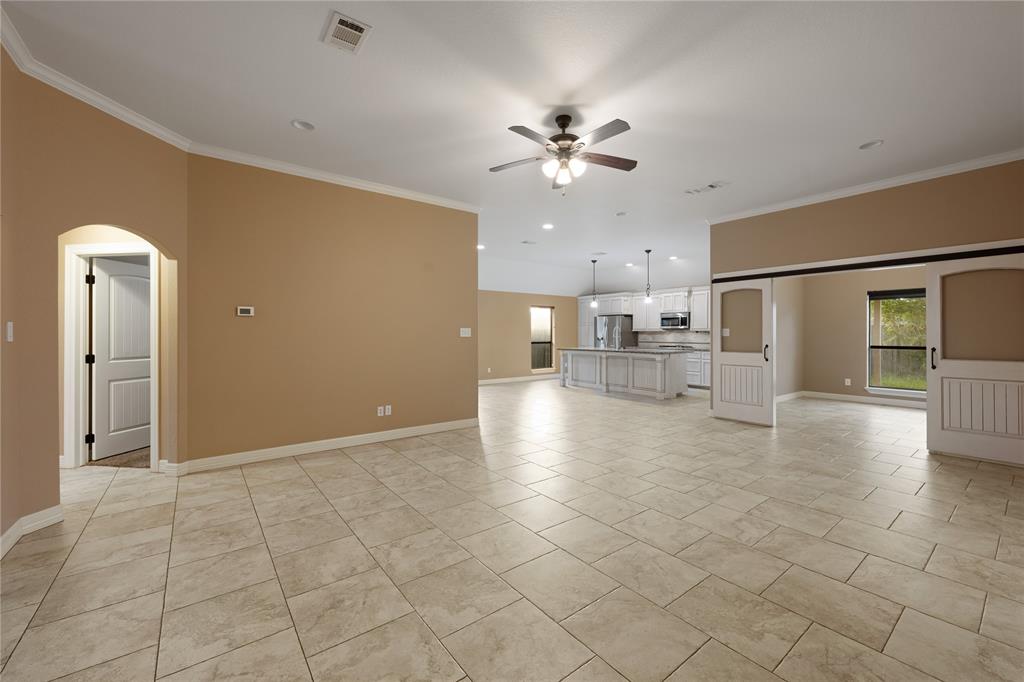 a view of an empty room and kitchen view