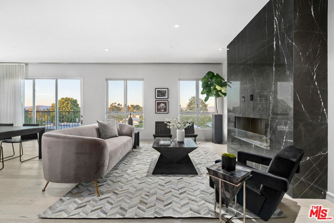 a living room with furniture a fireplace and a potted plant