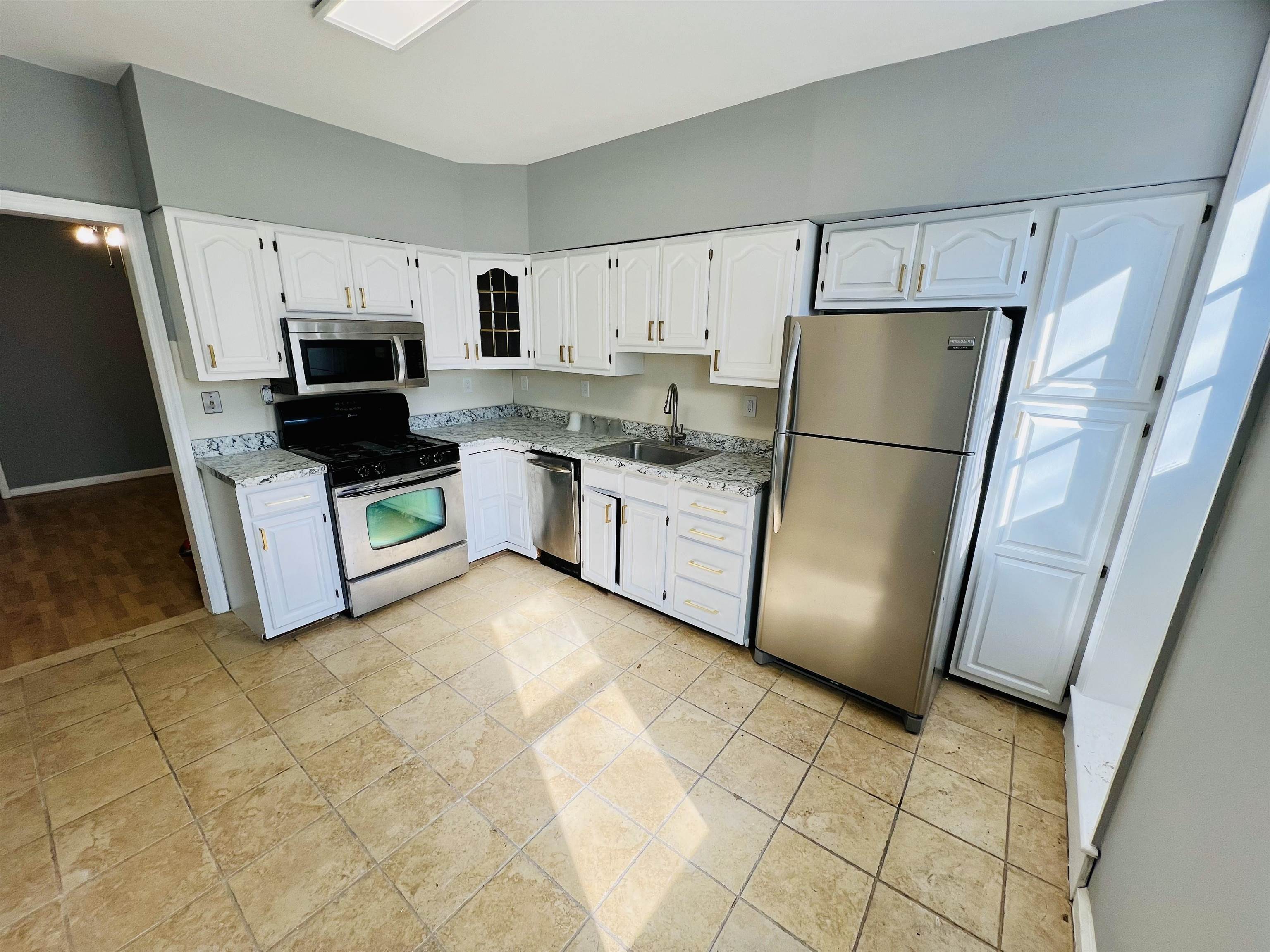 a kitchen with stainless steel appliances a refrigerator sink and microwave