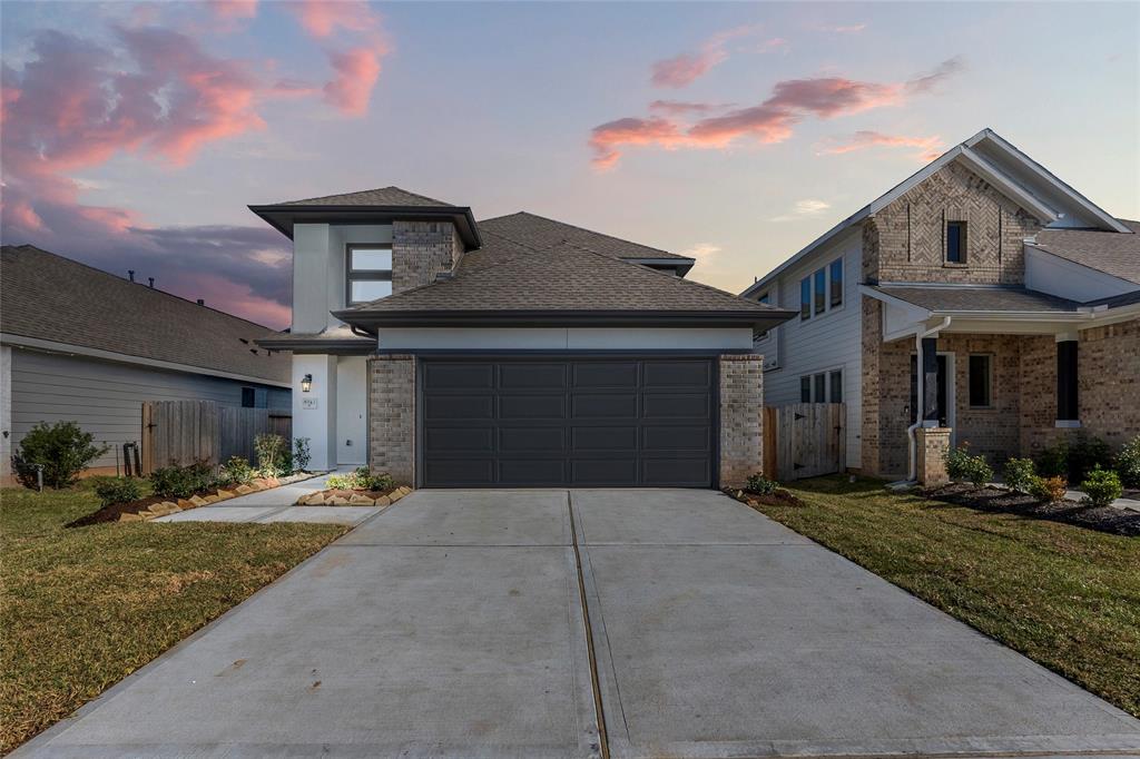 a front view of a house with a yard and garage