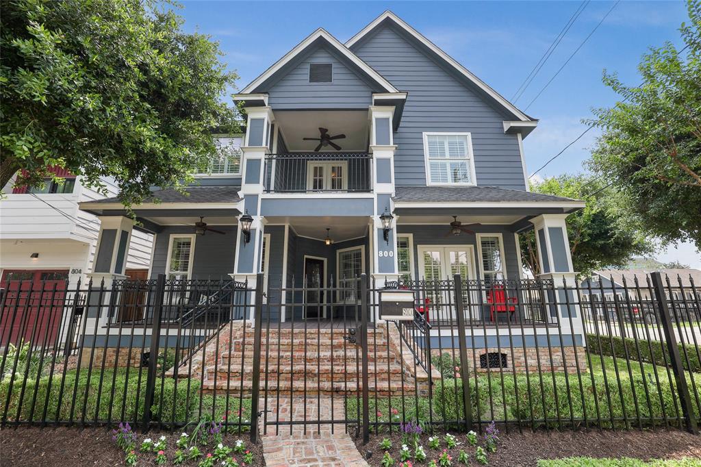 Nestled on a prime corner lot with 800 SF of covered patio space, this fully updated Craftsman-style home showcases a captivating front elevation with double gallery porches, wrought iron fence, lush landscaping, and a charming brick sidewalk.