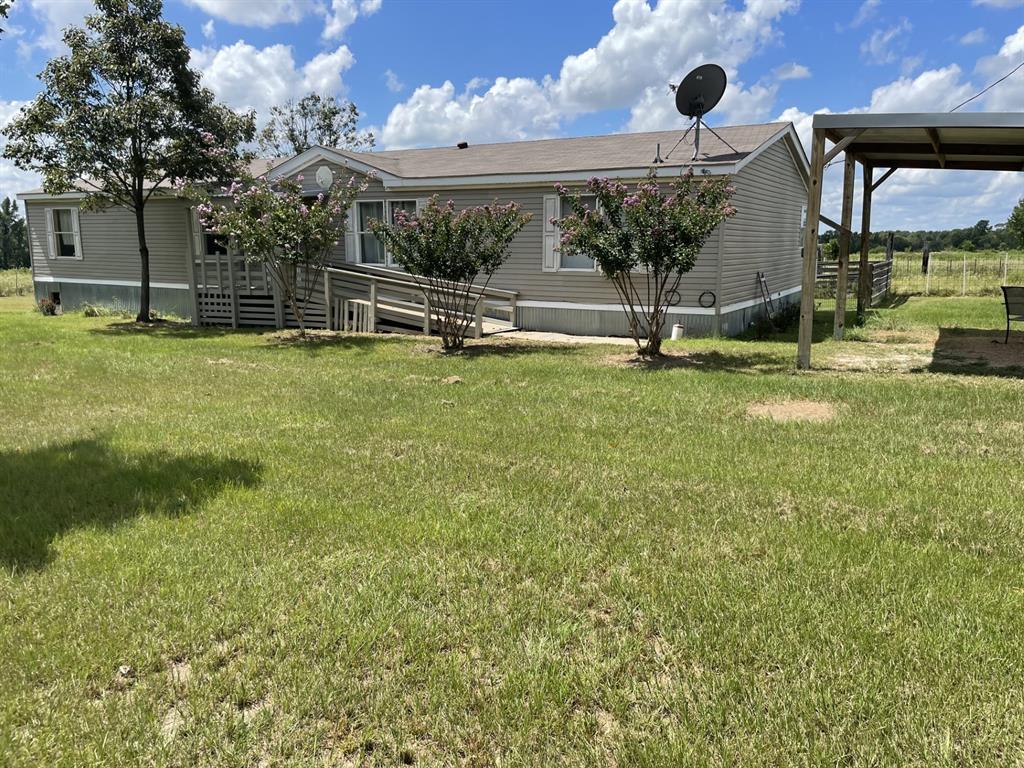 a view of a house with backyard and a tree