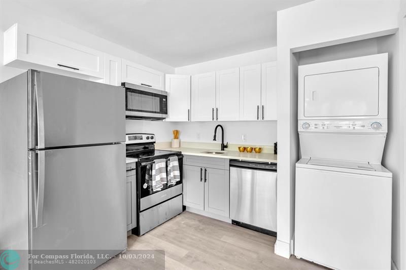 a kitchen with stainless steel appliances a refrigerator sink and microwave