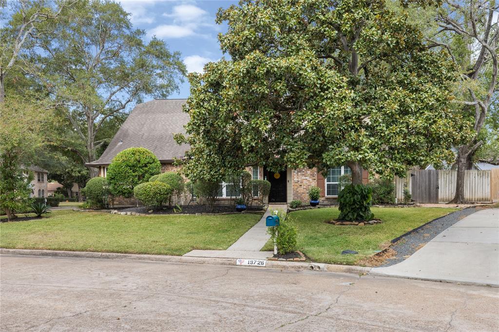 a view of a house with a big yard and large trees