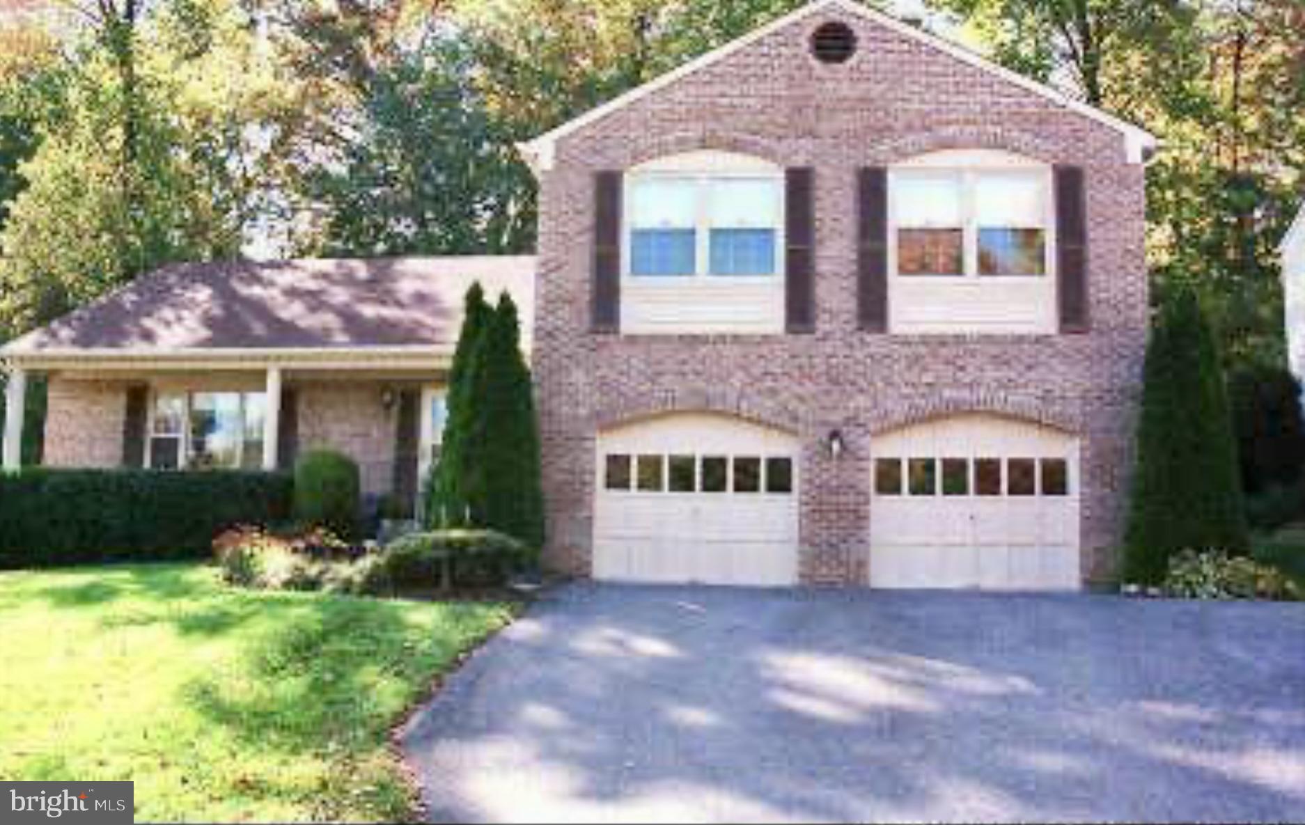 a front view of a house with yard and green space