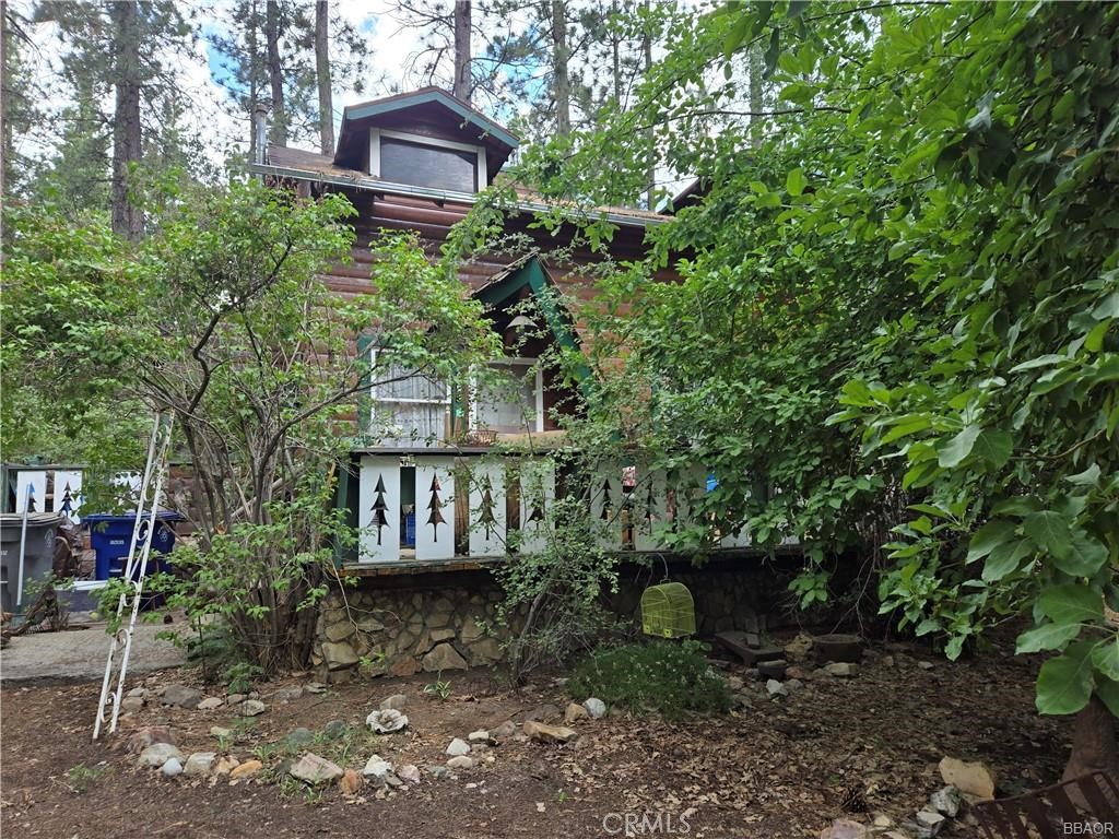 a front view of a house with a yard and potted plants