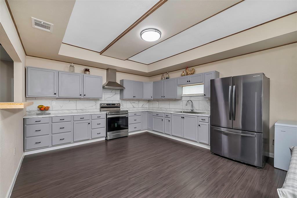 a kitchen with granite countertop white cabinets and stainless steel appliances