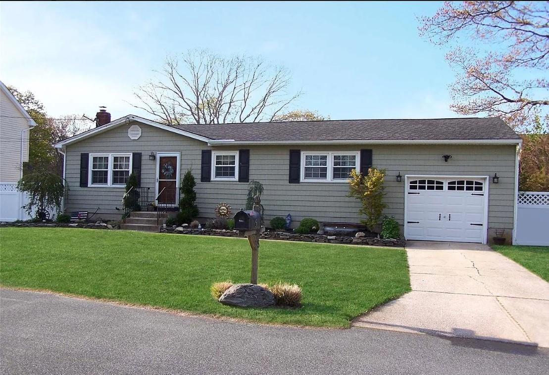 Ranch-style house featuring a front yard and a garage