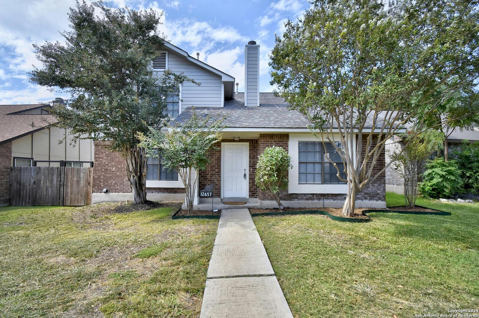 a view of a house with backyard and a tree