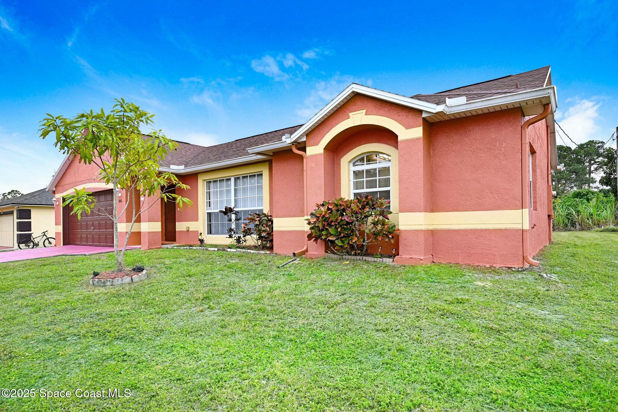 a front view of a house with a yard and garage