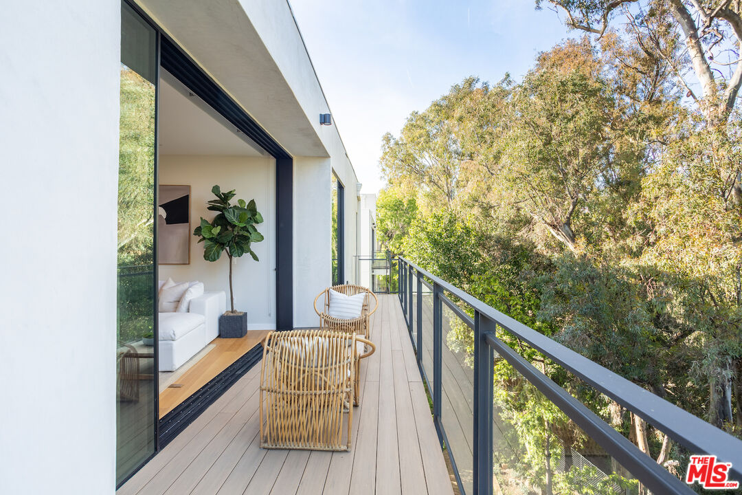 a view of balcony with wooden floor and seating space