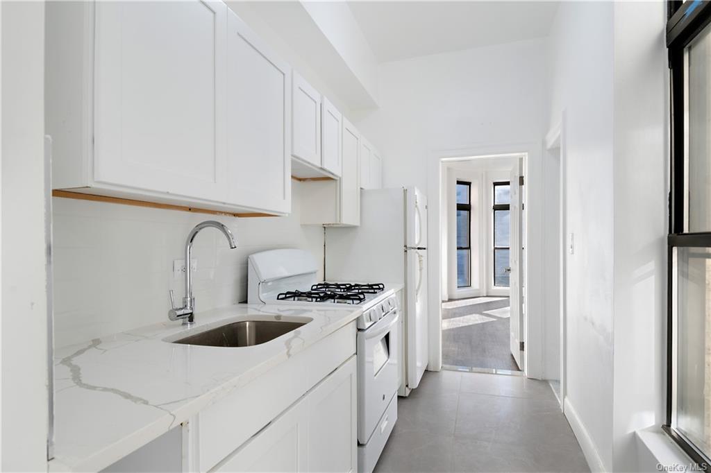 a kitchen with stainless steel appliances a white stove top oven and sink