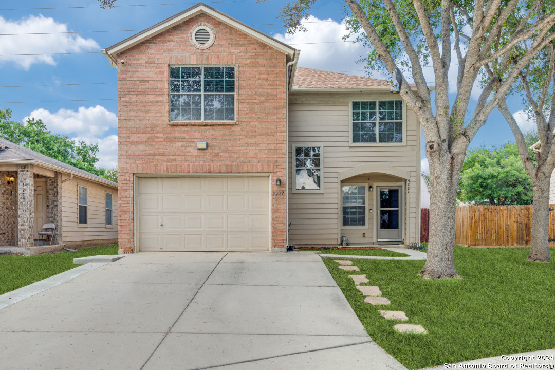 a front view of a house with a yard and garage