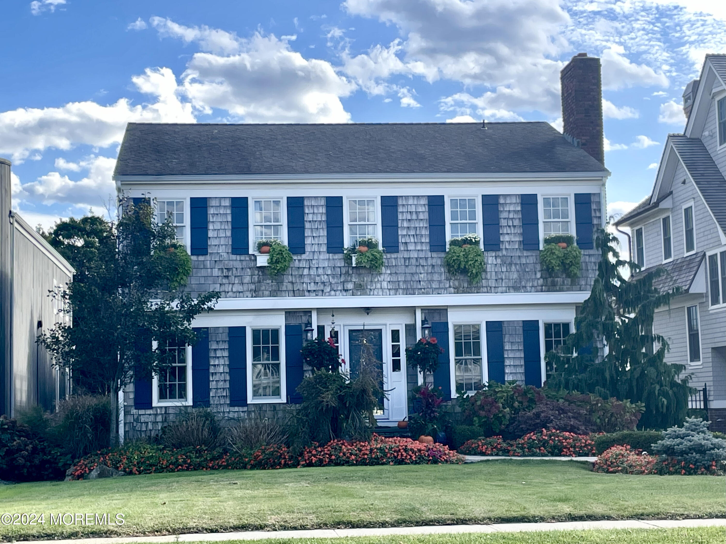 a front view of a house with a yard and a garden