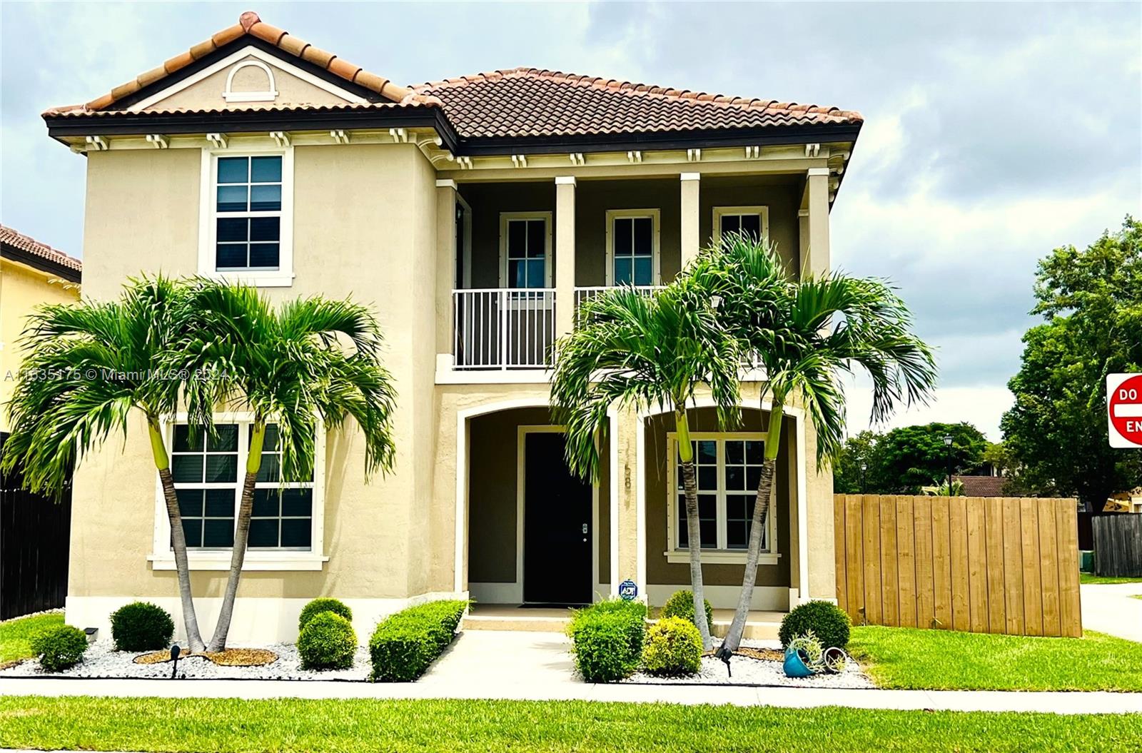 a front view of a house with a yard and potted plants