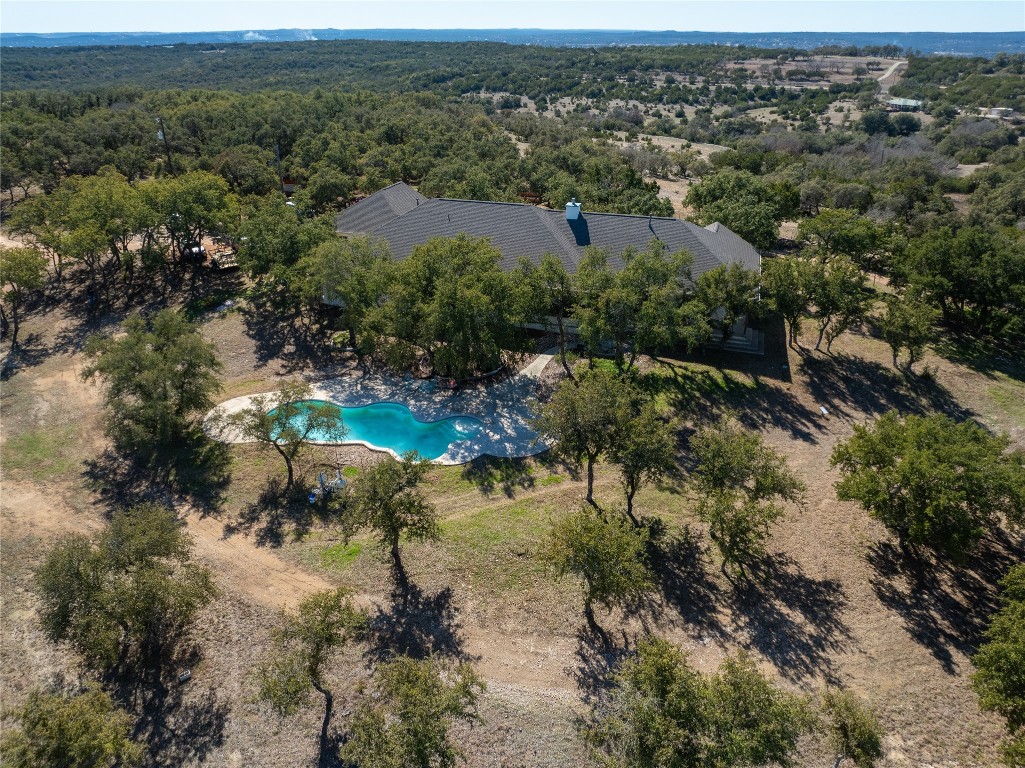 an aerial view of residential houses with outdoor space and trees