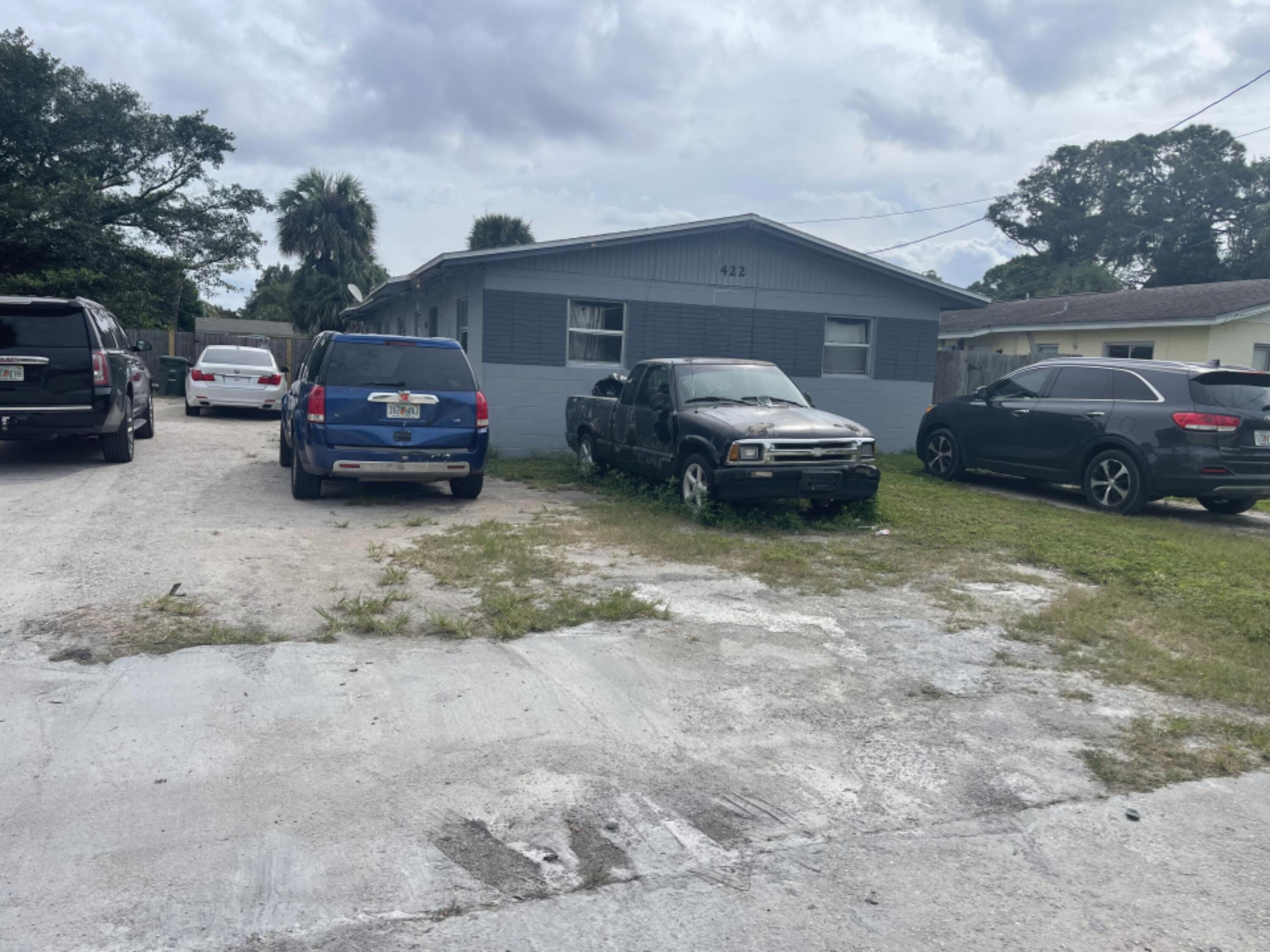 a front view of a house with cars parked