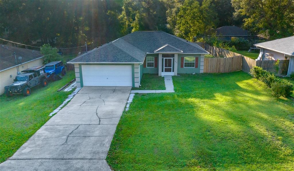 a front view of a house with a yard and trees