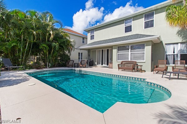 a view of a house with swimming pool and sitting area