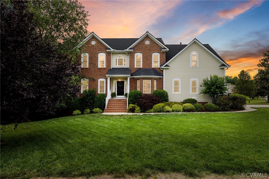 a front view of a house with a yard and trees