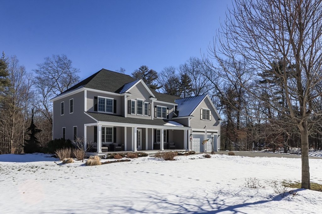 a front view of a house with a yard covered in snow