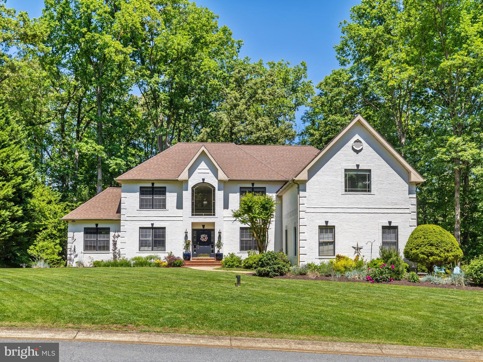 a front view of a white house with a yard