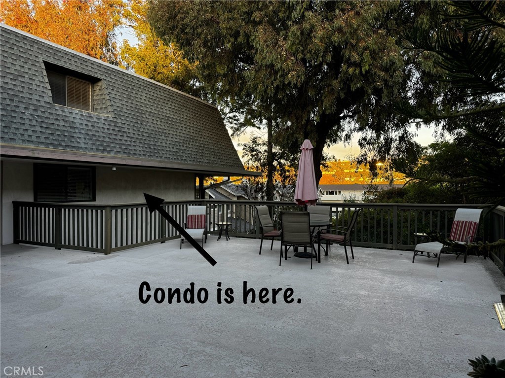 a view of roof deck with table and chairs and potted plants