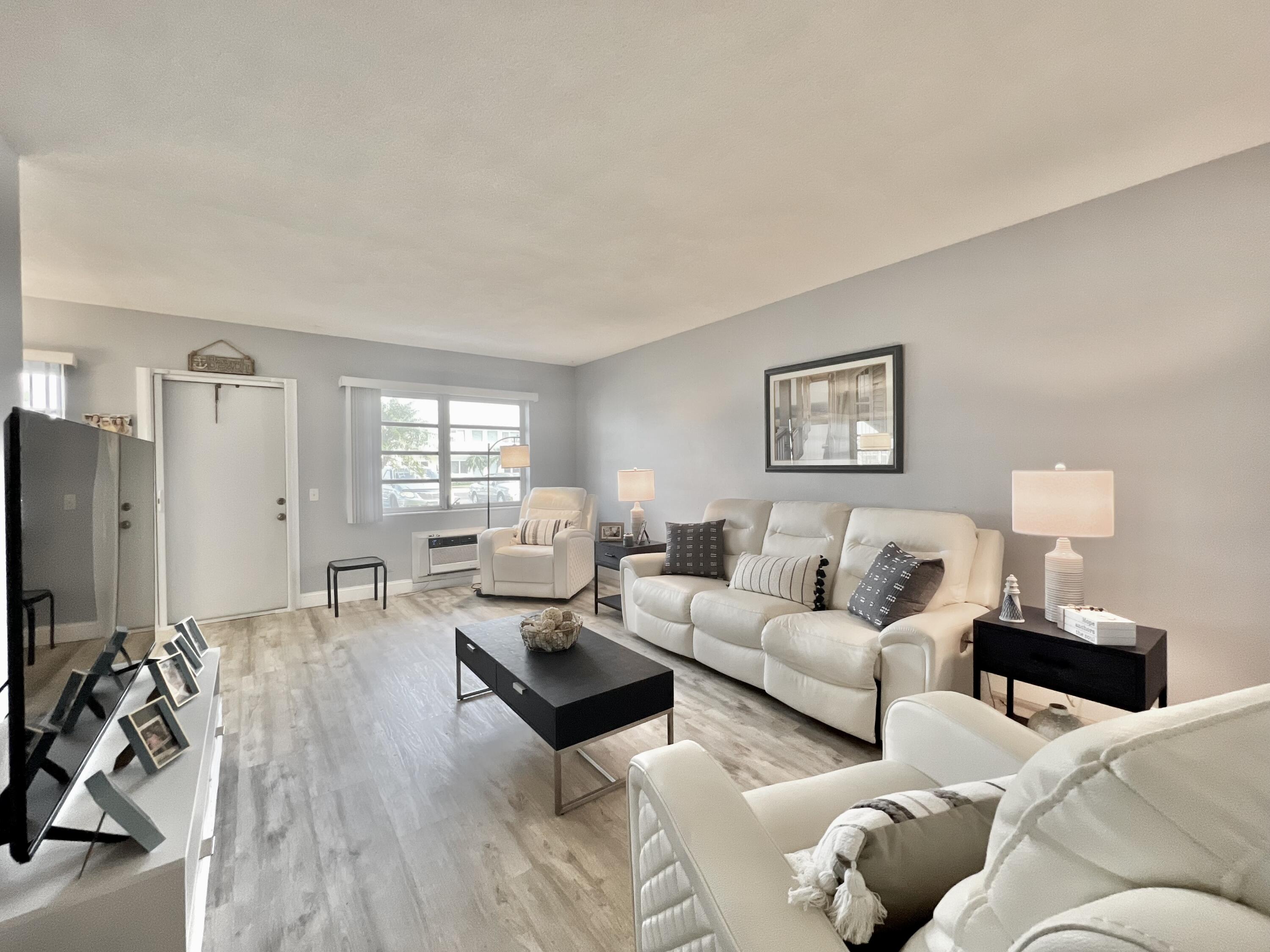 a living room with furniture a table and a flat screen tv