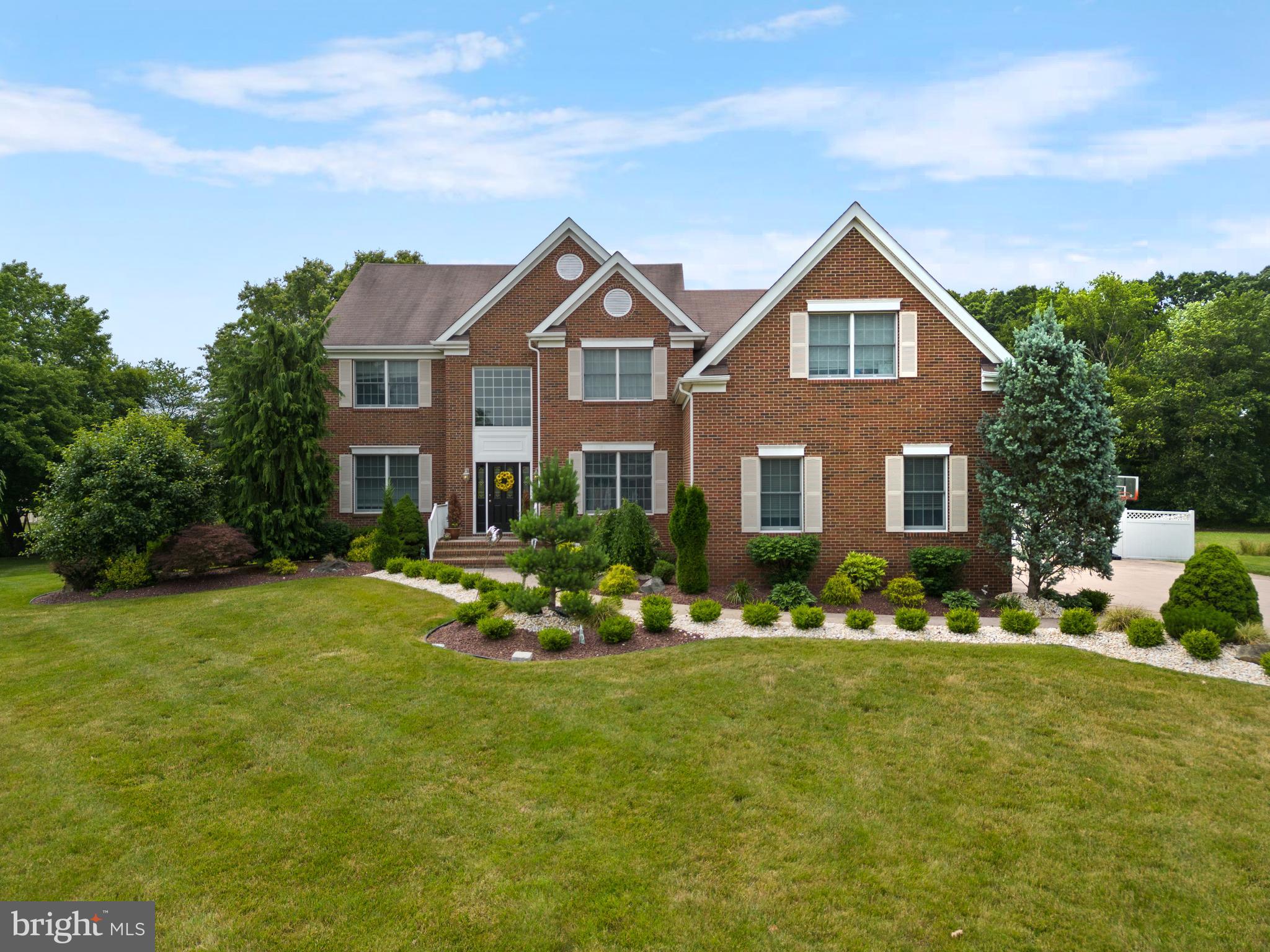 a front view of house with yard and trees in the background