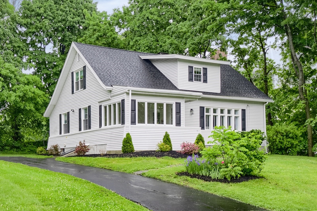 a front view of a house with a garden and plants