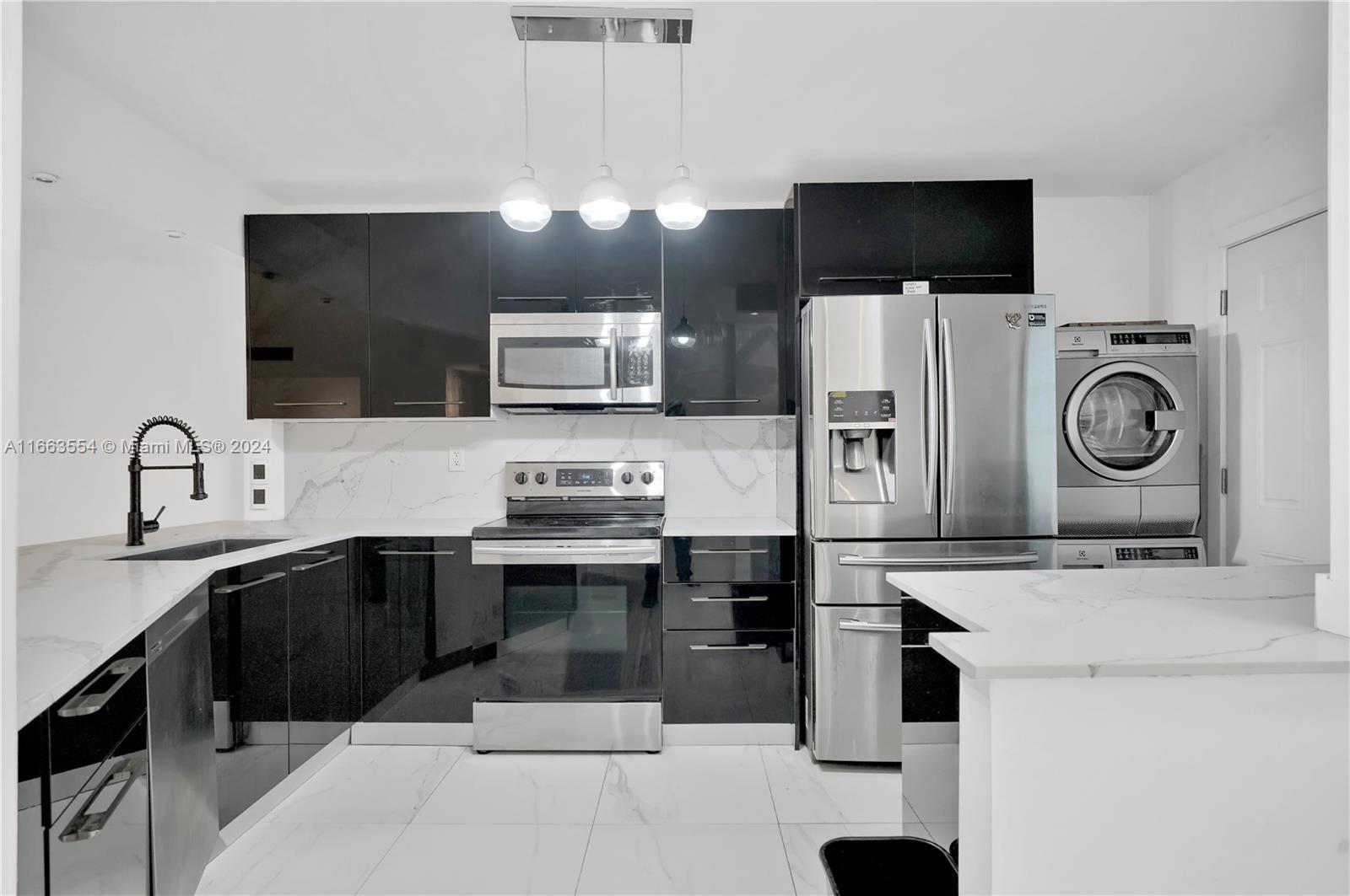 a kitchen with stainless steel appliances a stove a sink a microwave and refrigerator